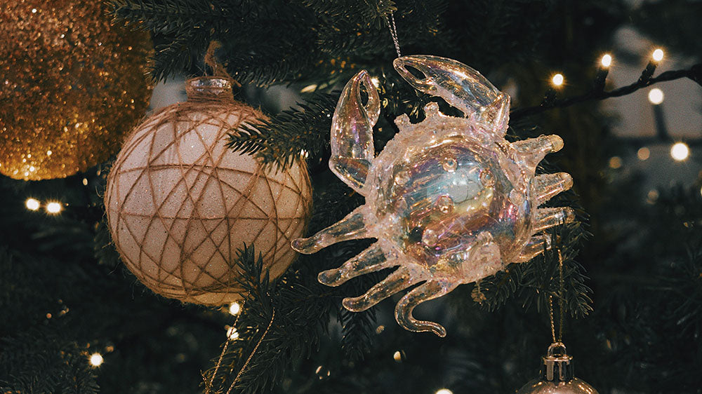 A festive holiday scene with a sparkly, crystalline crab ornament on a Christmas tree, highlighted by warm, glowing lights, symbolizing celebration and the magical aspect of the season.