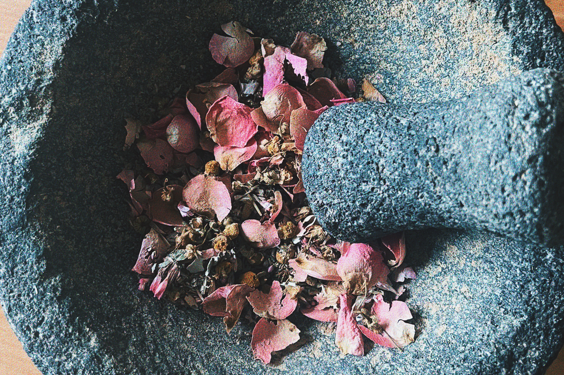 Mortar and Pestle filled with dried pink flowers.