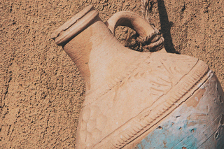 A clay water jar hangs in the sun symbolizing the Aquarius the Water-Bearer and the Sturgeon Full Moon.