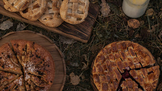 An autumn feast spread with pies and baked goods, surrounded by fallen leaves, evoking the spirit of Mabon’s harvest celebration.