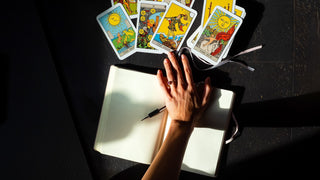 Tarot reading for the month ahead with The Fool, The Sun, and The Moon cards. A journal and pen sit beside the tarot spread, symbolizing self-reflection, planning, and clarity. Perfect for intention setting, personal growth.