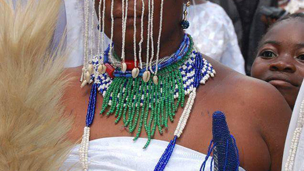 Yemaya devotee adorned in traditional beads and seashells at a cultural celebration, embodying the spirit of the Afro-Caribbean sea goddess.