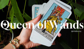 Queen of Wands tarot card held in hand against lush greenery, symbolizing confidence, joy, and the call to embrace play, spontaneity, and personal power this week.