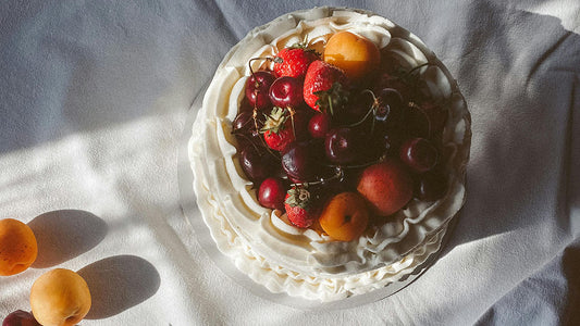 Strawberry Moon Cake: A beautifully decorated cake topped with fresh strawberries, cherries, and apricots, capturing the essence of the Strawberry Moon celebration.
