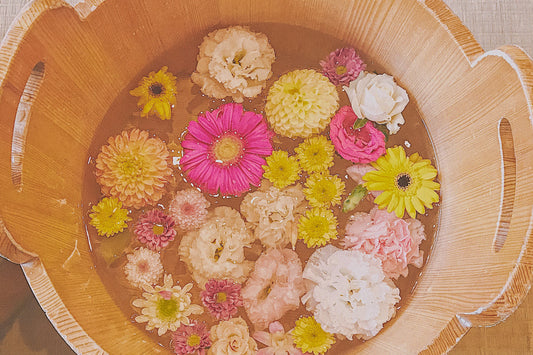 Wooden basin filled with water and colorful flowers