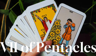 Hand holding a fanned-out deck of Rider-Waite tarot cards with the Seven of Pentacles prominently displayed, symbolizing patience, growth, and long-term effort.