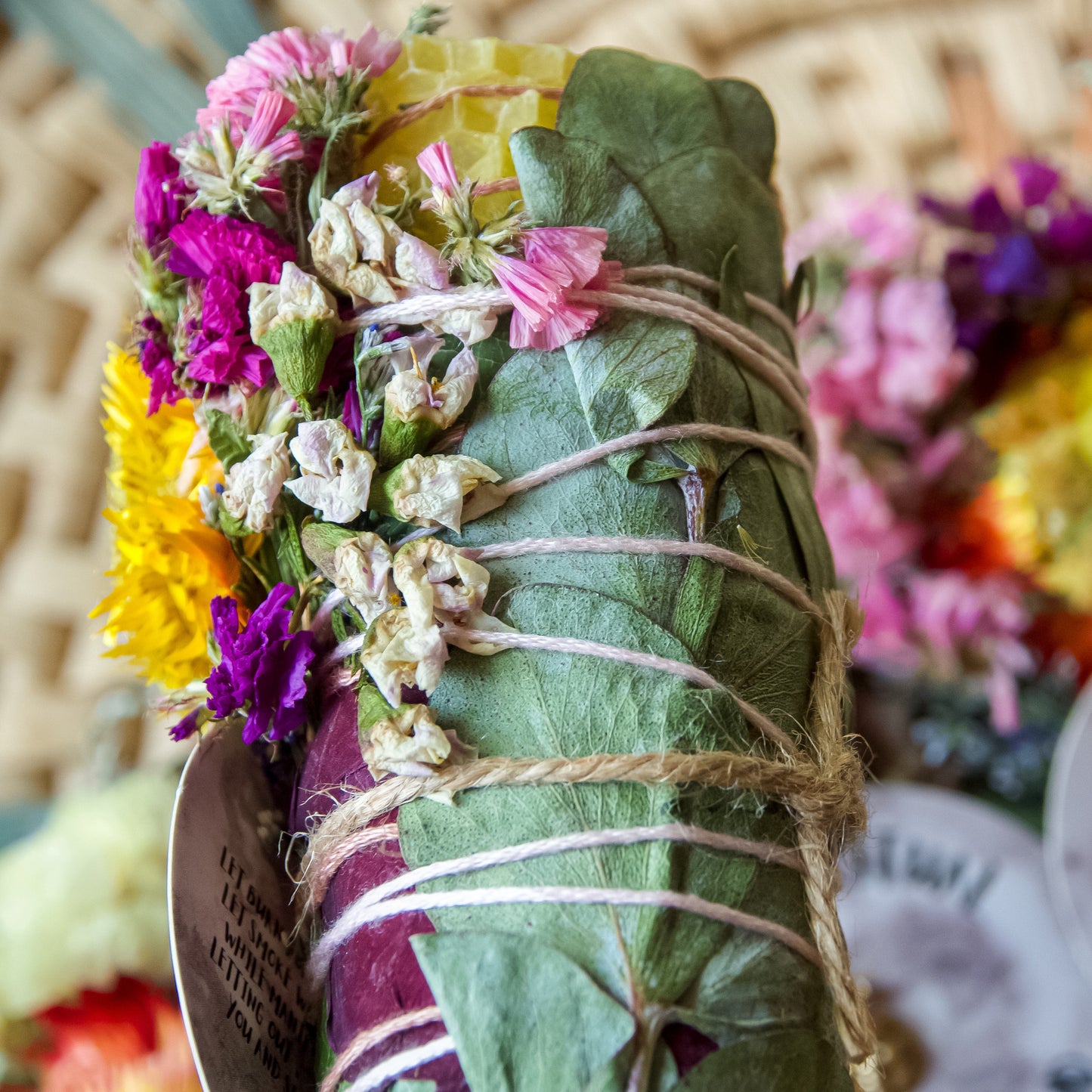  Full Moon Herbal Torch, a hand-wrapped sage wand with ethically sourced white sage, beeswax, local herbs, flowers, and garden greens, with a gold pendant attached.